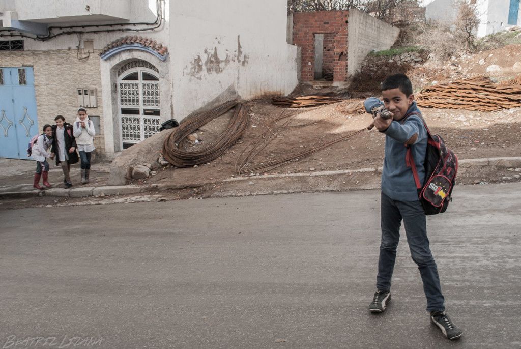 Niño disparando con paraguas en Chefchaouen